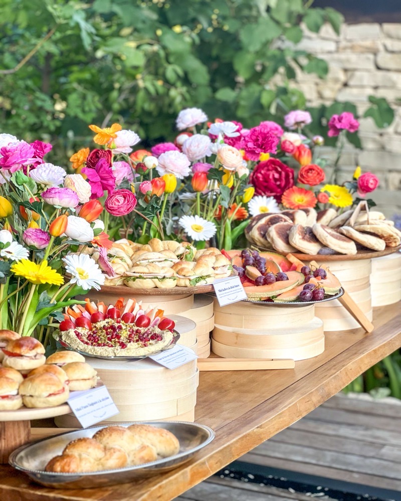 Buffet L'Apéritif fait maison Entre L à Aix-en-Provence, dressé en plein air entre des fleurs : hallot, crème de fêta, fruits et pains pita