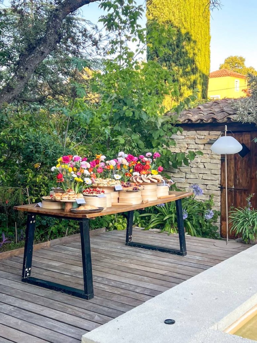 Buffet fleuri Entre L dressé dans un jardin provençal près d'Aix-en-Provence, au bord d'une piscine, sous un cyprès