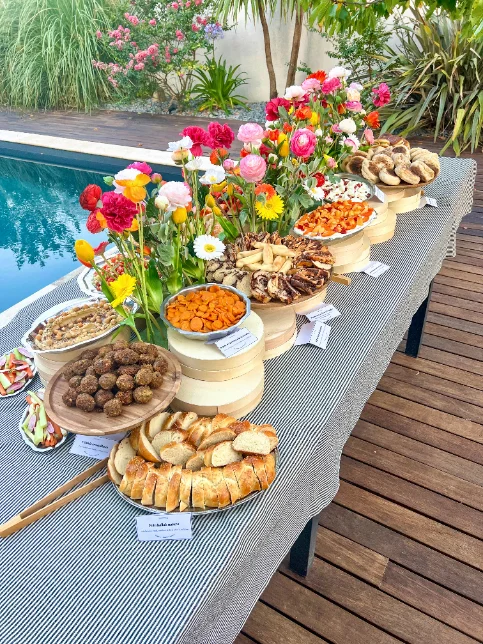 Buffet dressé au bord d'une piscine, habillé de fleurs