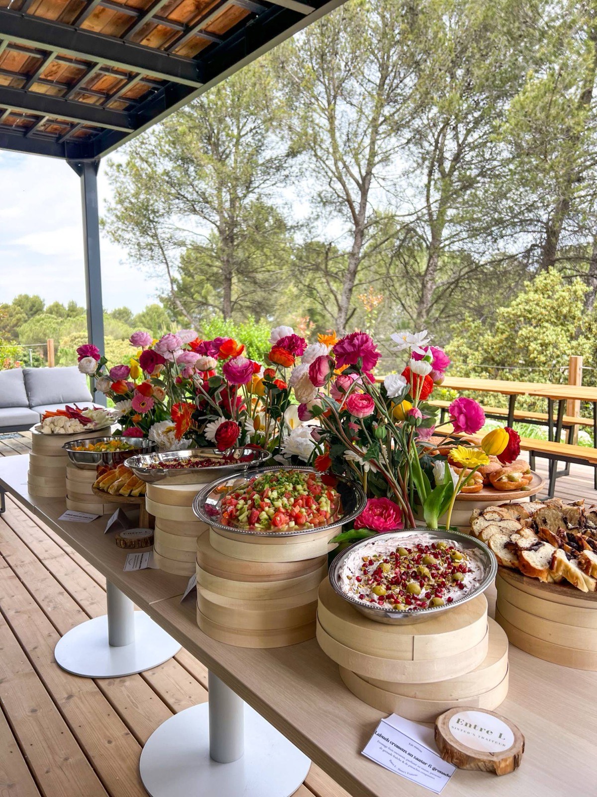 Buffet Entre L sous une pergola : labneh crémeux au zaatar et grenade, salade de légumes et babka