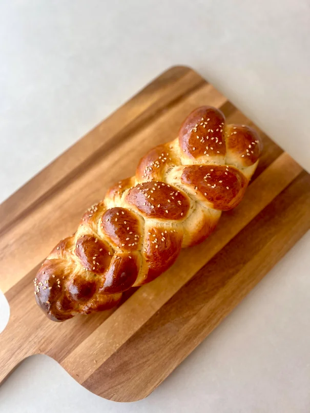 Hallah dorée et tressée sur une planche en bois